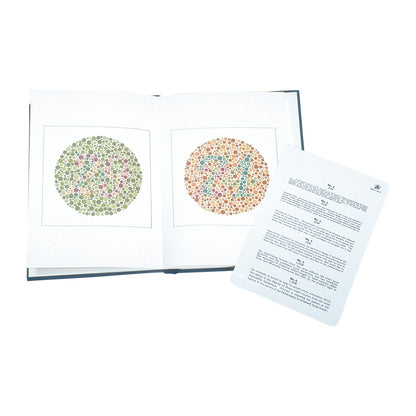 An open book displaying two Ishihara Color-Blindness Test plates with numbers 25 and 74 in colored dots, next to an explanatory sheet.