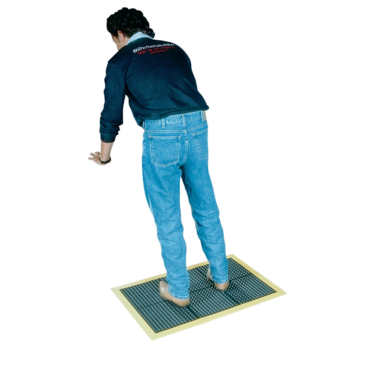 A person stands on a Wearwell Ortho Stand Anti-Fatigue Mat. The mat is rectangular, with a textured surface and bordered edges.
