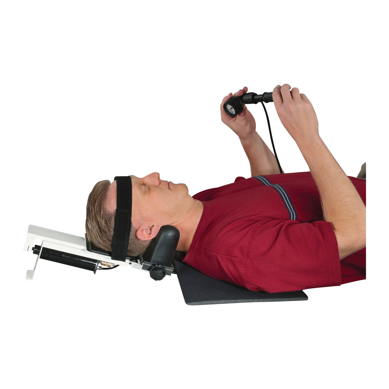 A person uses the Saunders Cervical HomeTrac Deluxe, a device for cervical traction, while lying on their back with a head strap.