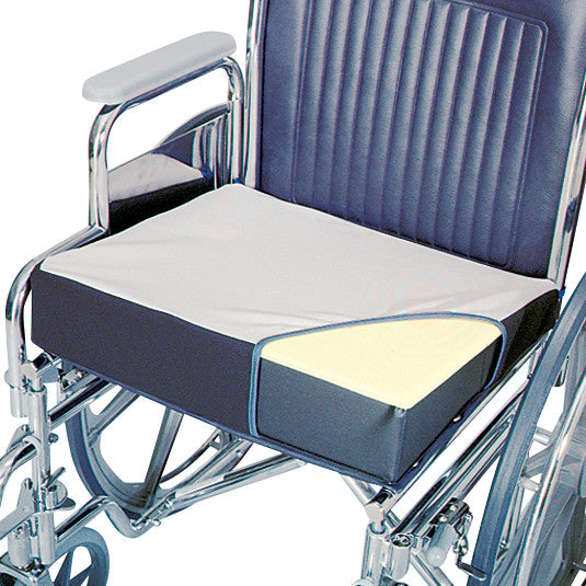 A close-up of a wheelchair with a SkiL-Care Foam Wheelchair Wedge cushion, featuring a non-slip cover on the seat.