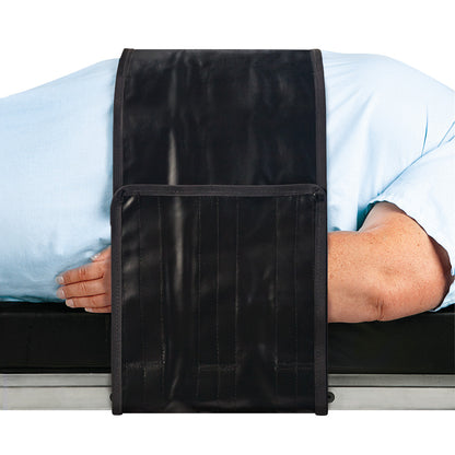 A person lies on their side with an AliMed Nonmetallic Operating Room Table Strap securing them in place on the table.