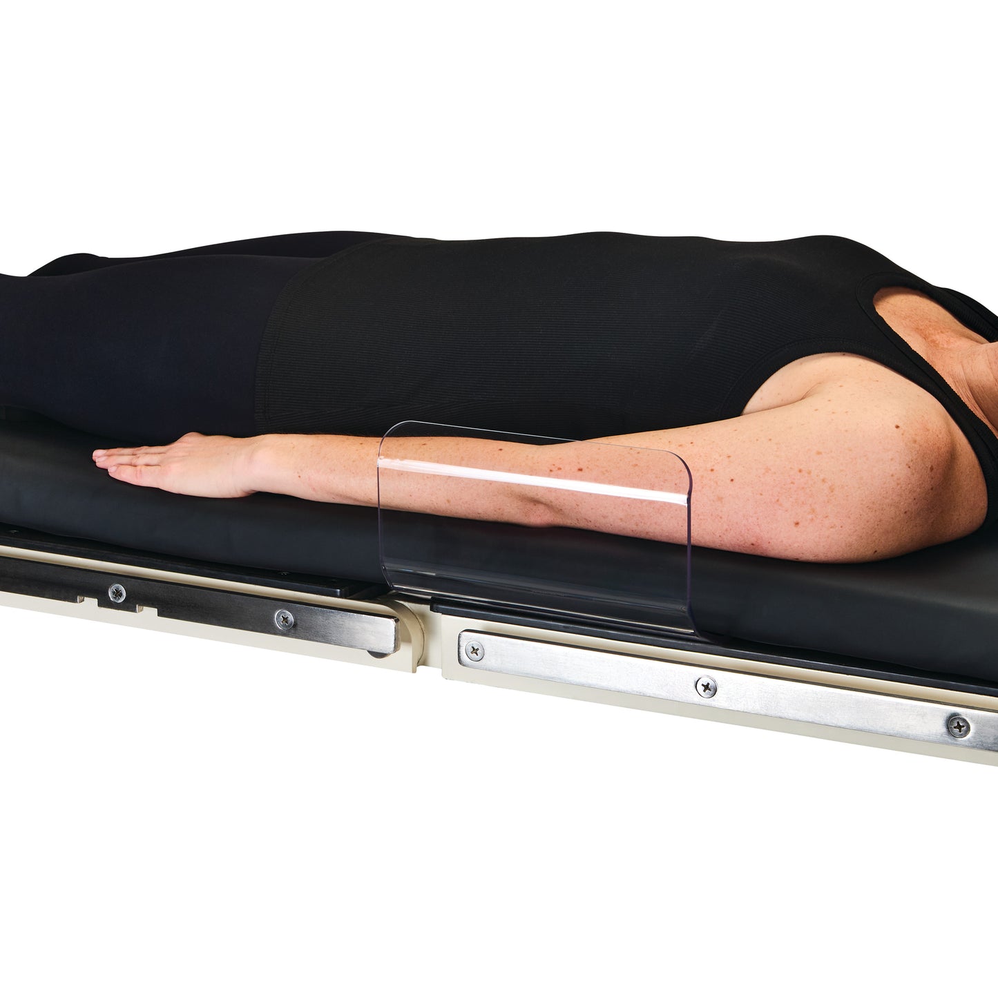 A person lies on a table with an AliMed Curved Toboggan Arm/Leg Guard protecting their arm, preventing it from falling off.