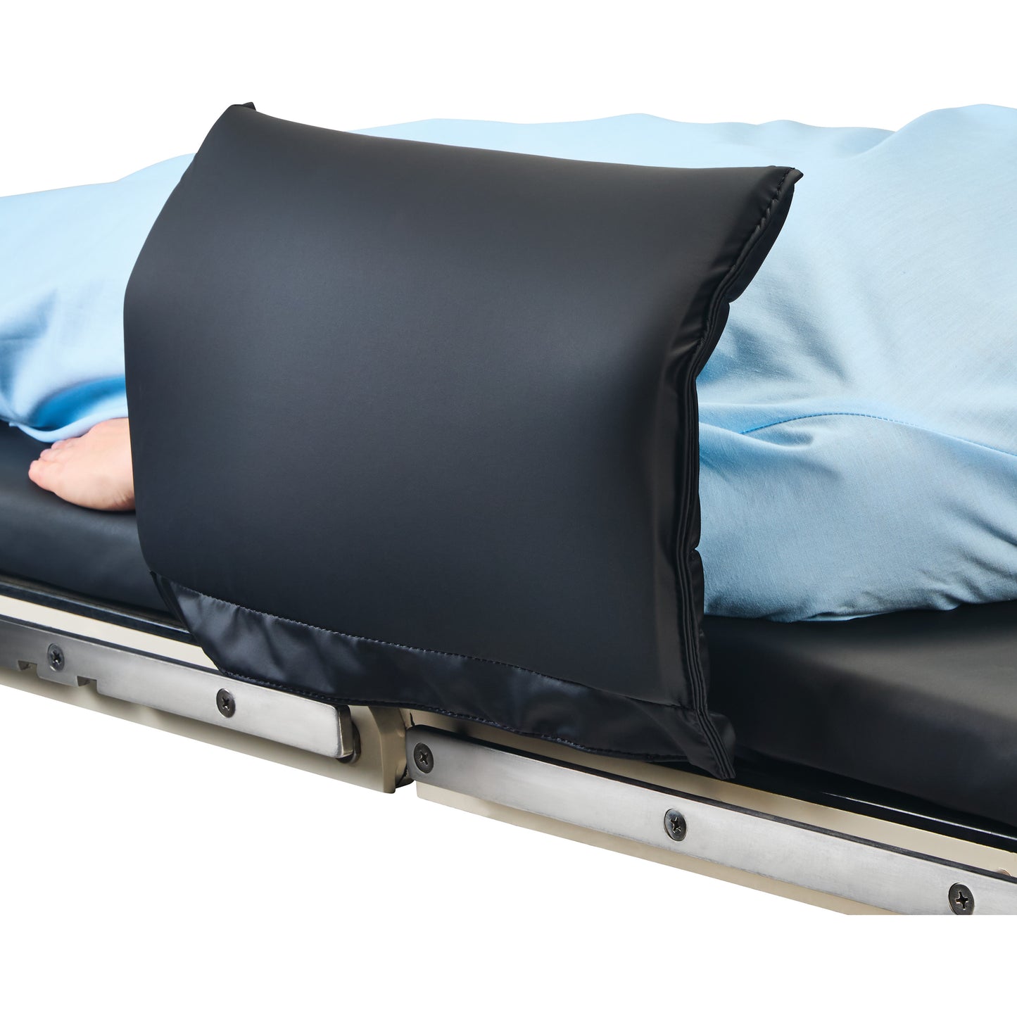 A person lies on a hospital bed with a blue sheet, using an AliMed Padded Toboggan Cover at the side of the bed for support.