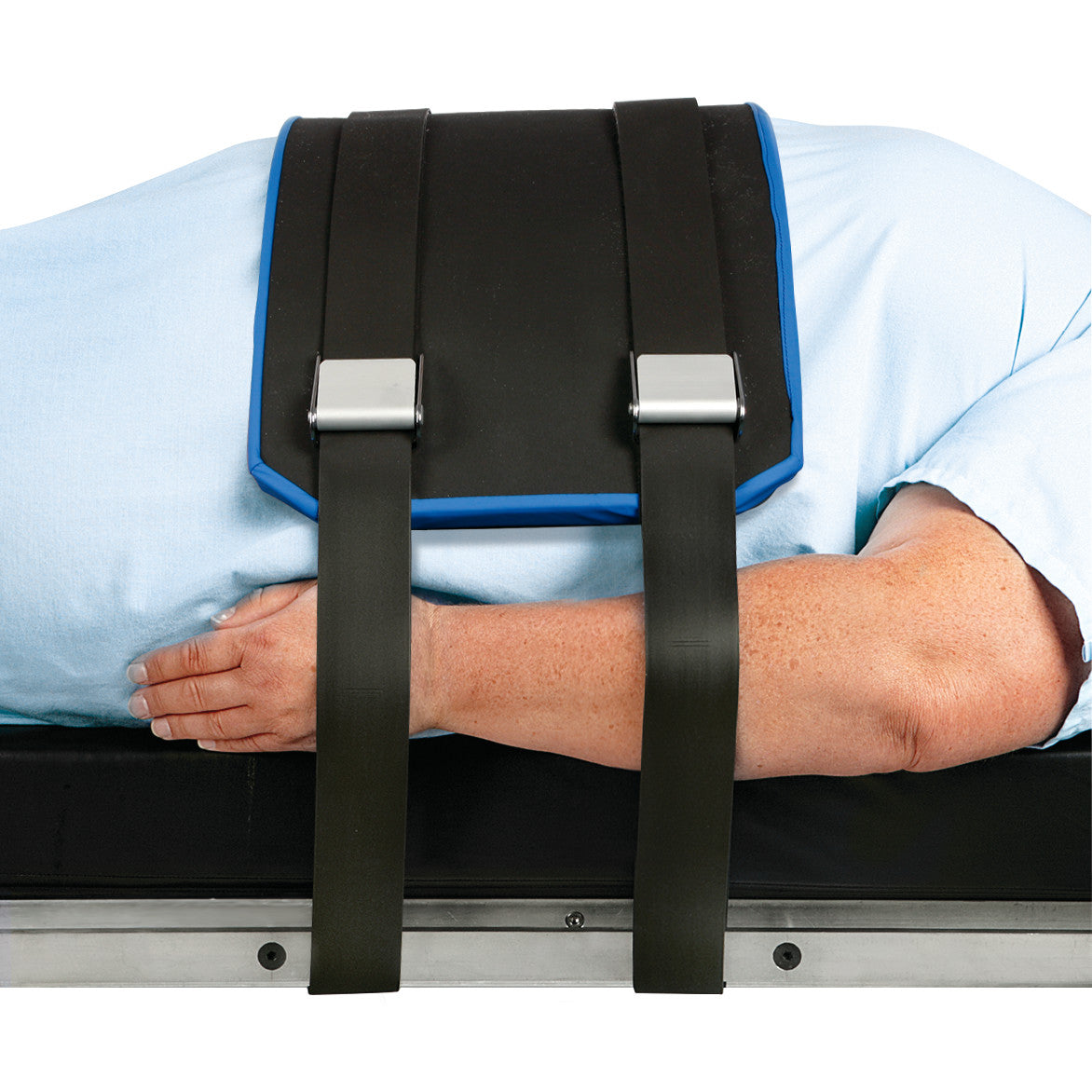 A person restrained by the AliMed Bariatric Super Strap, lying on their side. The strap is black with metal fasteners.