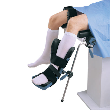 A patient's leg is secured in an Allen Arthroscopic Well Leg Holder with padded straps, wearing white socks above a blue drape.