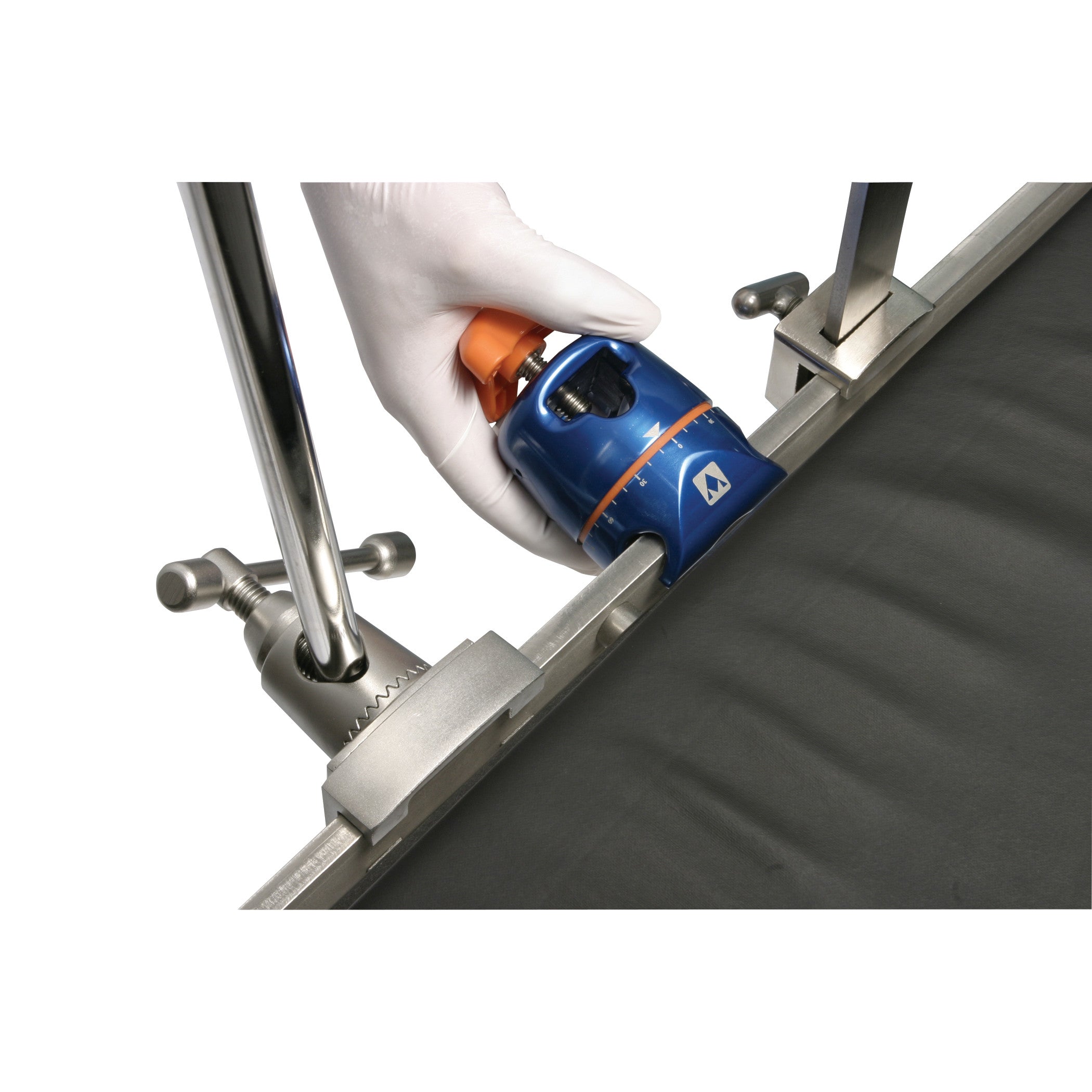 A hand wearing a glove adjusts the AliMed FREEDOM Clark Socket Table Clamp, which is attached to a metal rail on a surface.