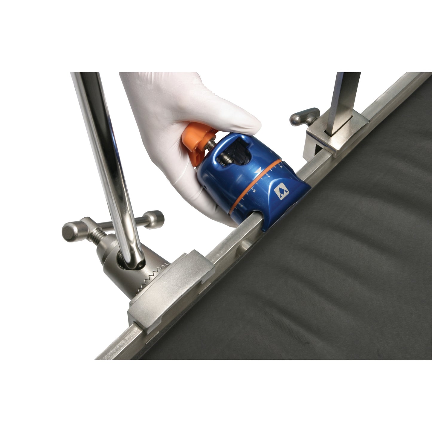 A hand wearing a glove adjusts the AliMed FREEDOM Clark Socket Table Clamp, which is attached to a metal rail on a surface.