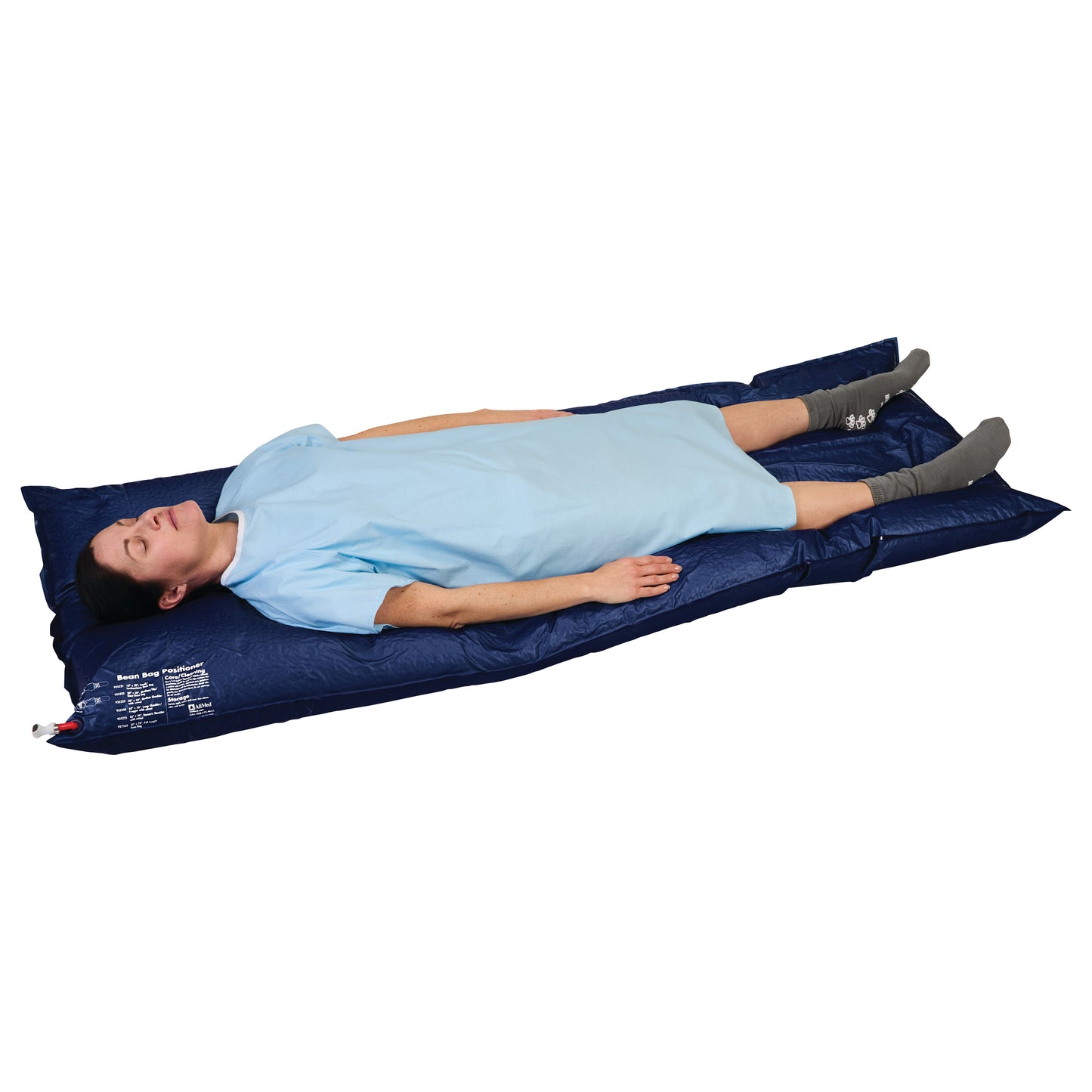 A person lies on an AliMed Bean Bag Positioner with Cutout, wearing a blue gown and gray socks.
