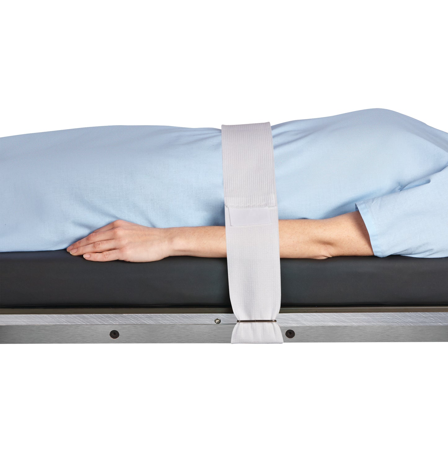 A person lies on a table secured with a Halyard Operating Room Table/Stretcher Strap over their body, wearing a light blue garment.