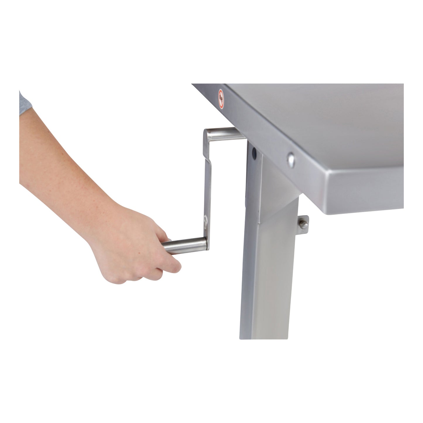 A hand operates the crank of a Blickman Georgetown Manual Adjustable Instrument Table, adjusting the table height.
