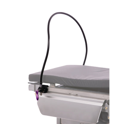 A KYRA Flexible Anesthesia Screen attached to the side of a medical table, featuring a flexible arm and a purple handle.