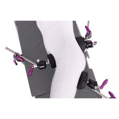 The KYRA Lateral Positioning Set secures a mannequin leg with multiple padded clamps and purple levers for medical positioning.