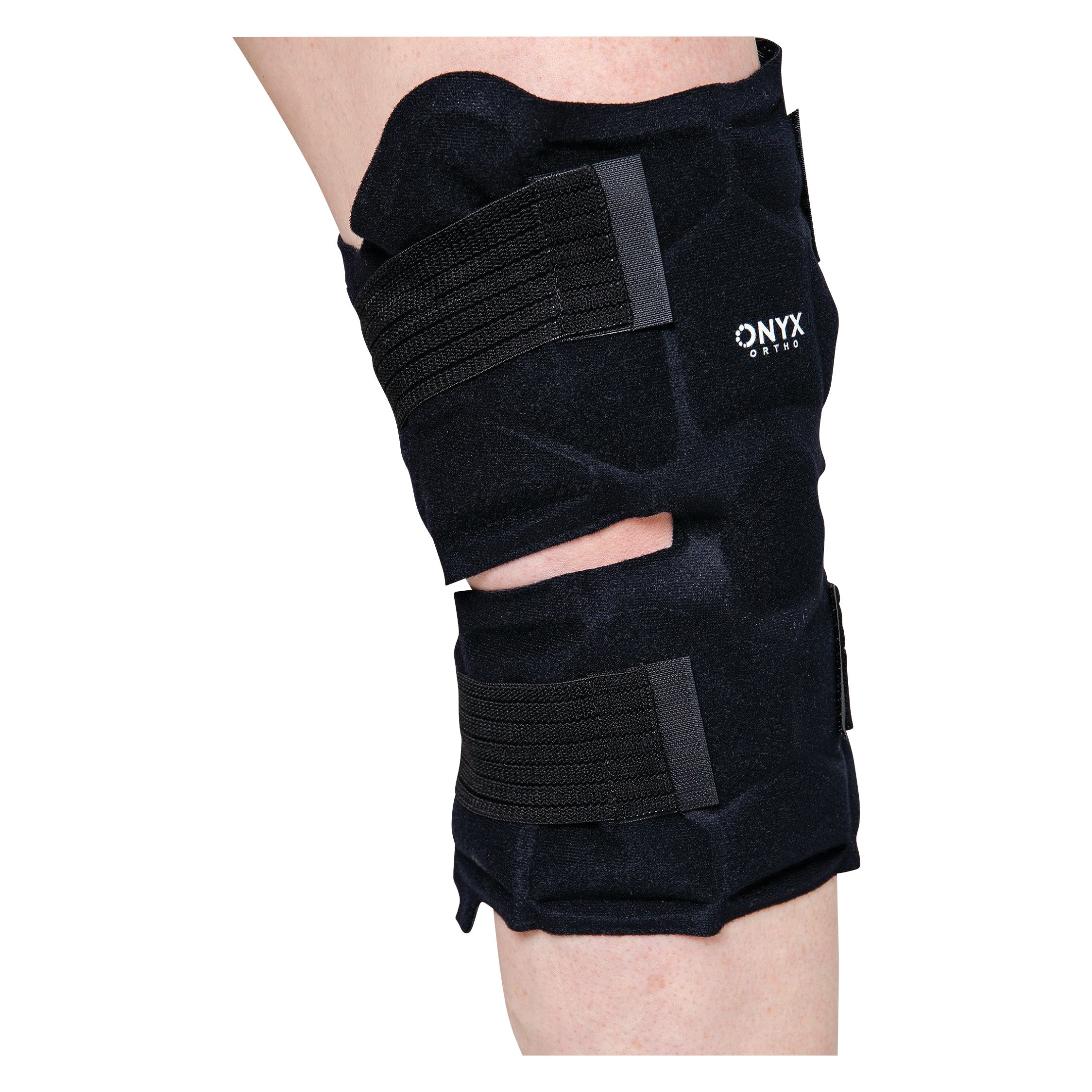 A person wears a Xena Therapies Onyx Cool Knee brace with black straps on their leg, providing support and compression.