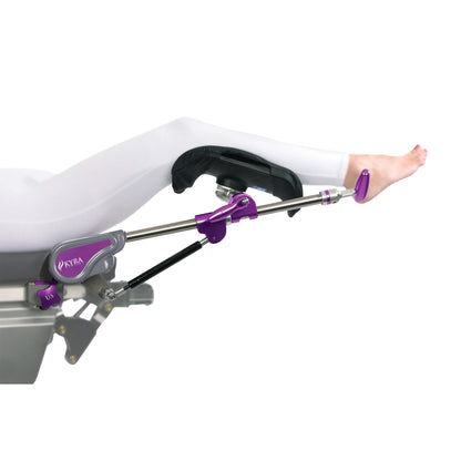 A patient's leg is supported by a KYRA Lift Assist Knee Crutch, featuring purple and silver components, attached to a medical table.