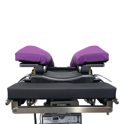 KYRA Curve Spine Frame with purple cushions and a black base, used in medical settings for patient positioning during procedures.