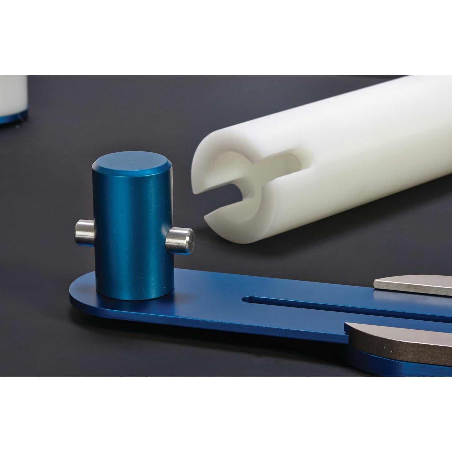 AliMed Anterior Lateral Positioner with blue and white components on a dark surface, featuring cylindrical and curved shapes.
