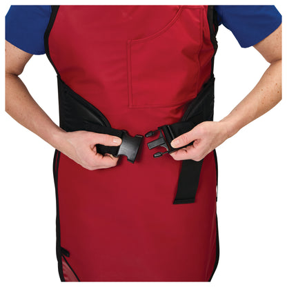A person fastens an AliMed Back Saver Belt over a red protective apron. The belt features a plastic buckle closure.
