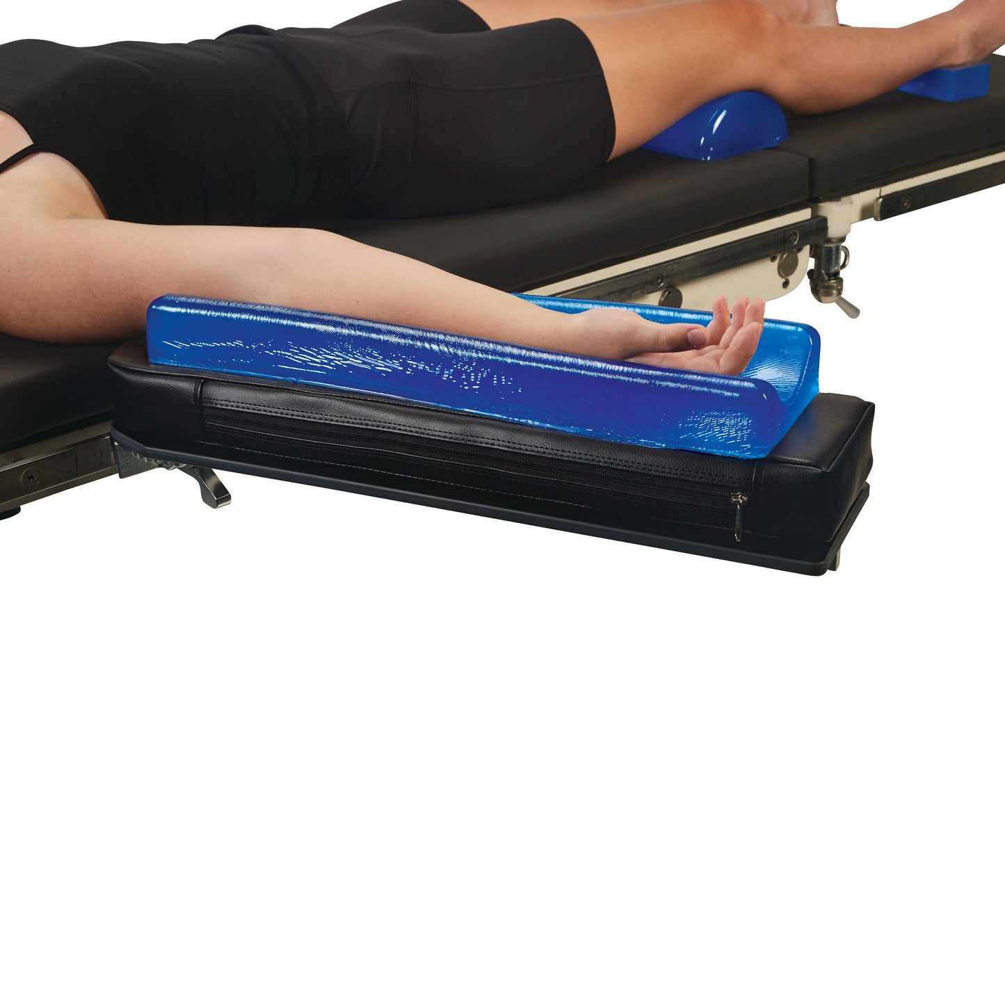 A person rests their arm on the AliMed AliBlue Gel Contoured Armboard Pad, positioned on a medical table.