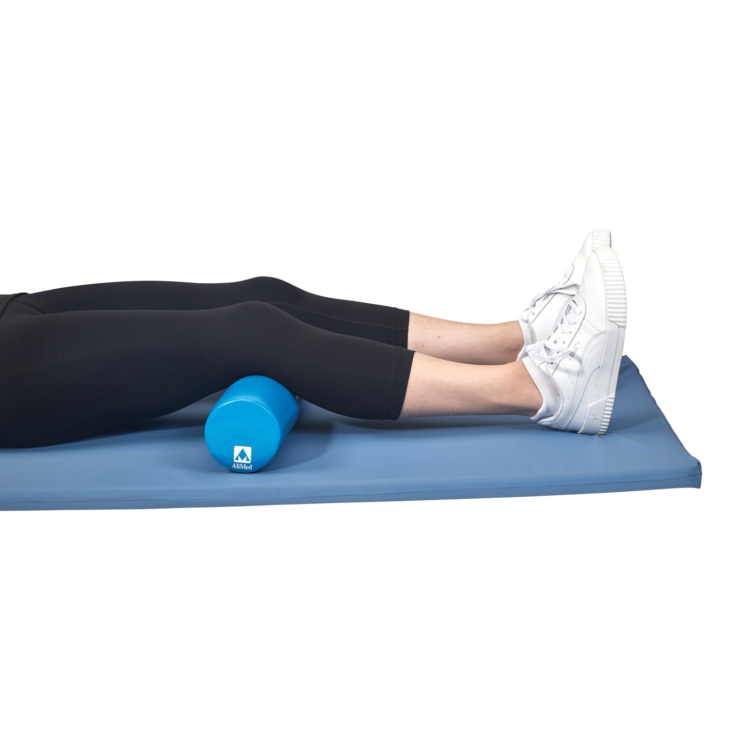 A person lies on a blue mat with legs elevated on an AliMed Antimicrobial-Treated Therapy Positioning Roll.
