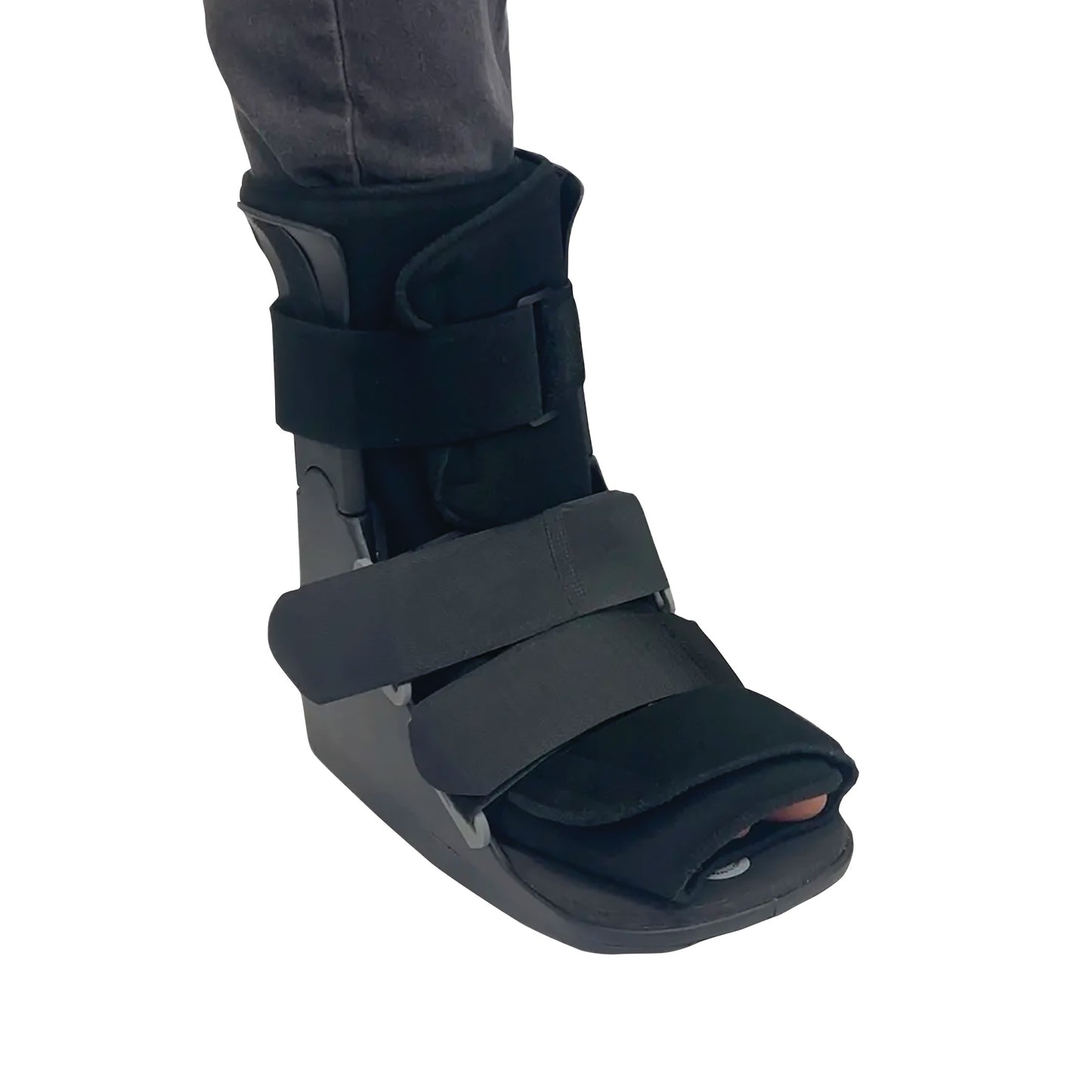 A DARCO FX Pro Low Walker boot with black straps is worn on a person's foot, offering support and protection.