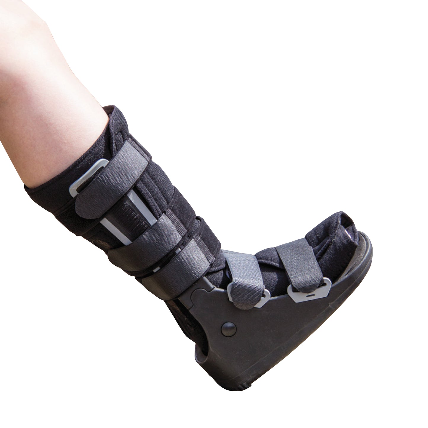 A person wears a DARCO FX Pro High Walker boot, featuring black material with gray straps for support and immobilization.