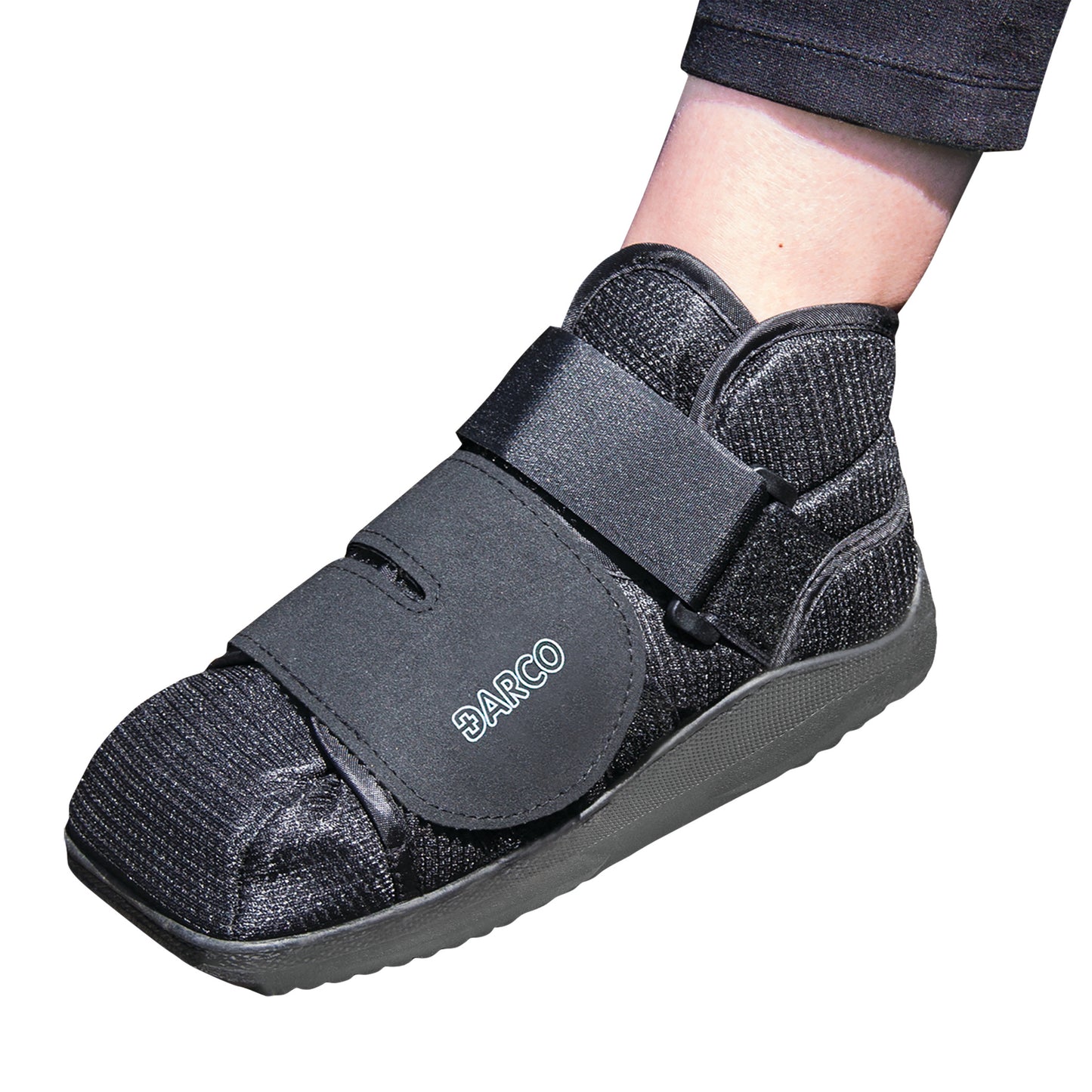 A person wears a DARCO APB Shoe, designed for medical use, featuring a black knit design and adjustable straps for support.