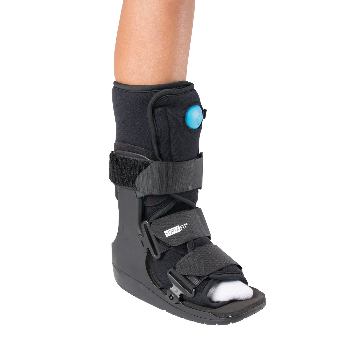 A person wearing an �ssur Formfit Low-Top Air Walker. The black boot has adjustable straps and a visible air pump on the side.