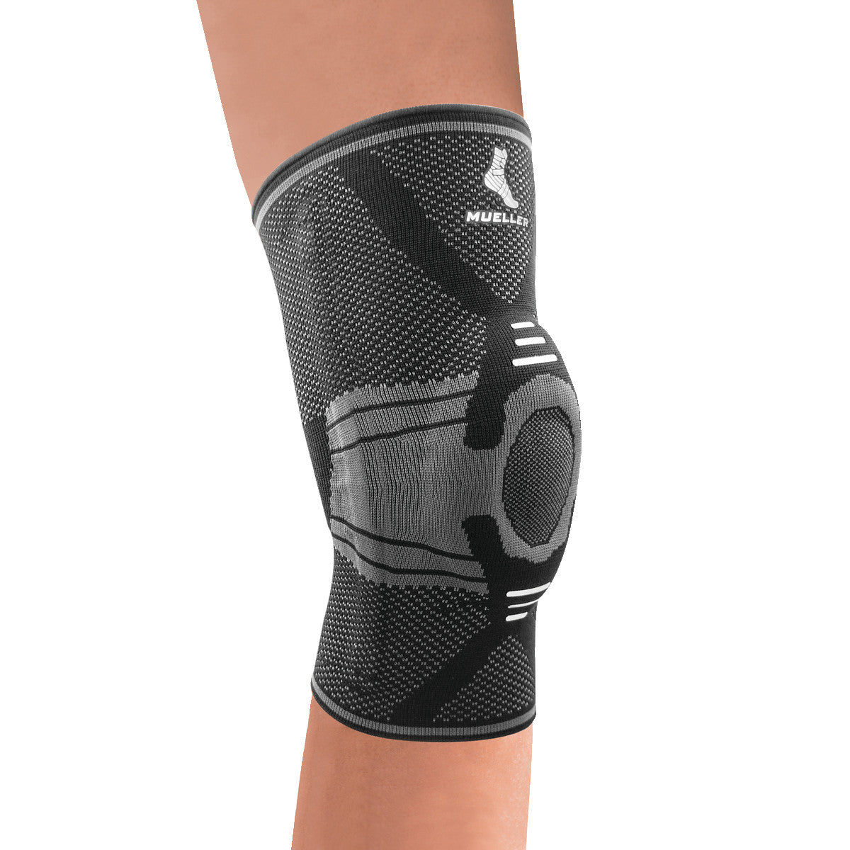 A Mueller Omniforce Knee Stabilizer worn on a leg, featuring a black and gray knitted design with a circular opening at the knee.