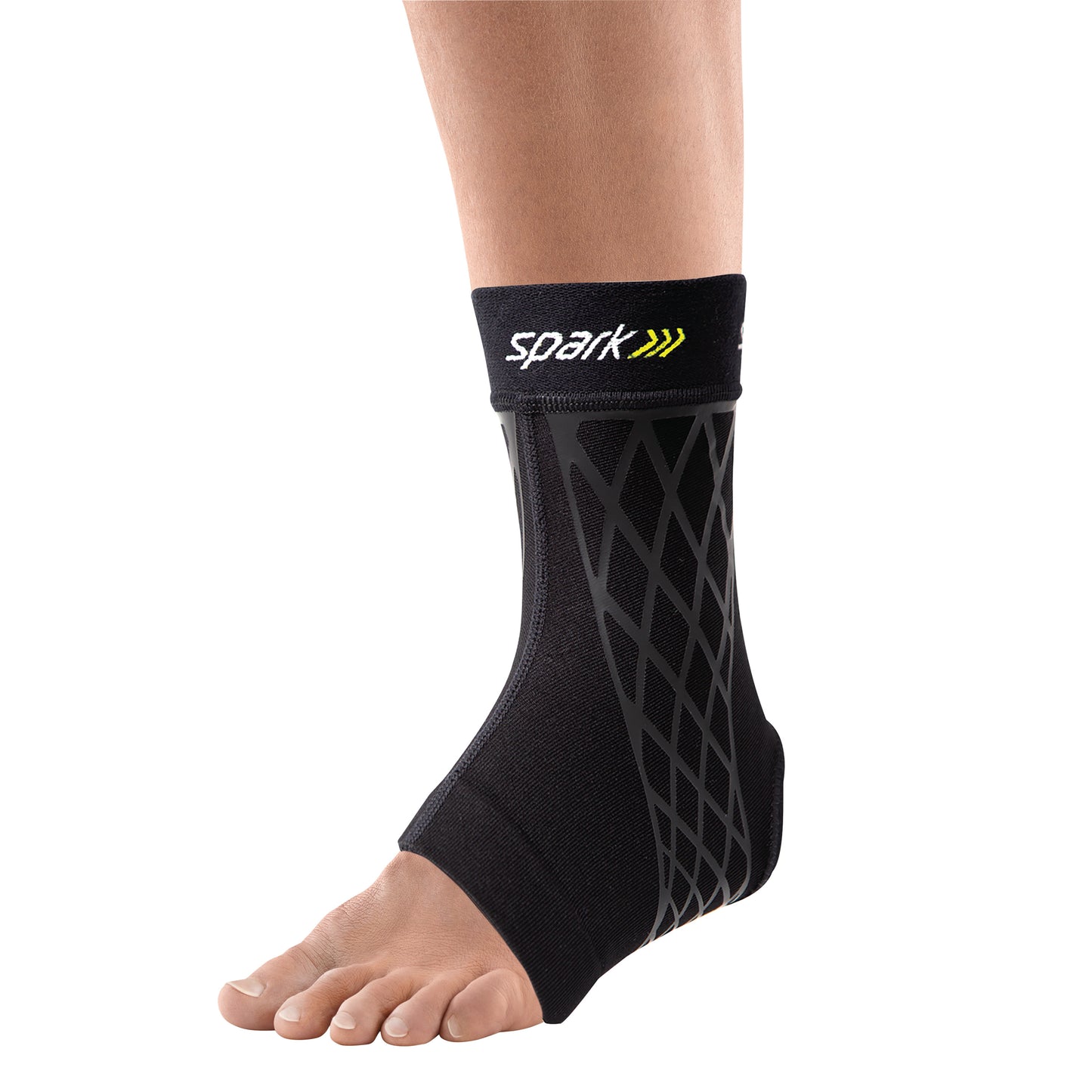 An ankle with a Brownmed Spark Kinetic Ankle Sleeve, featuring a black design with diagonal patterns and an open toe area.