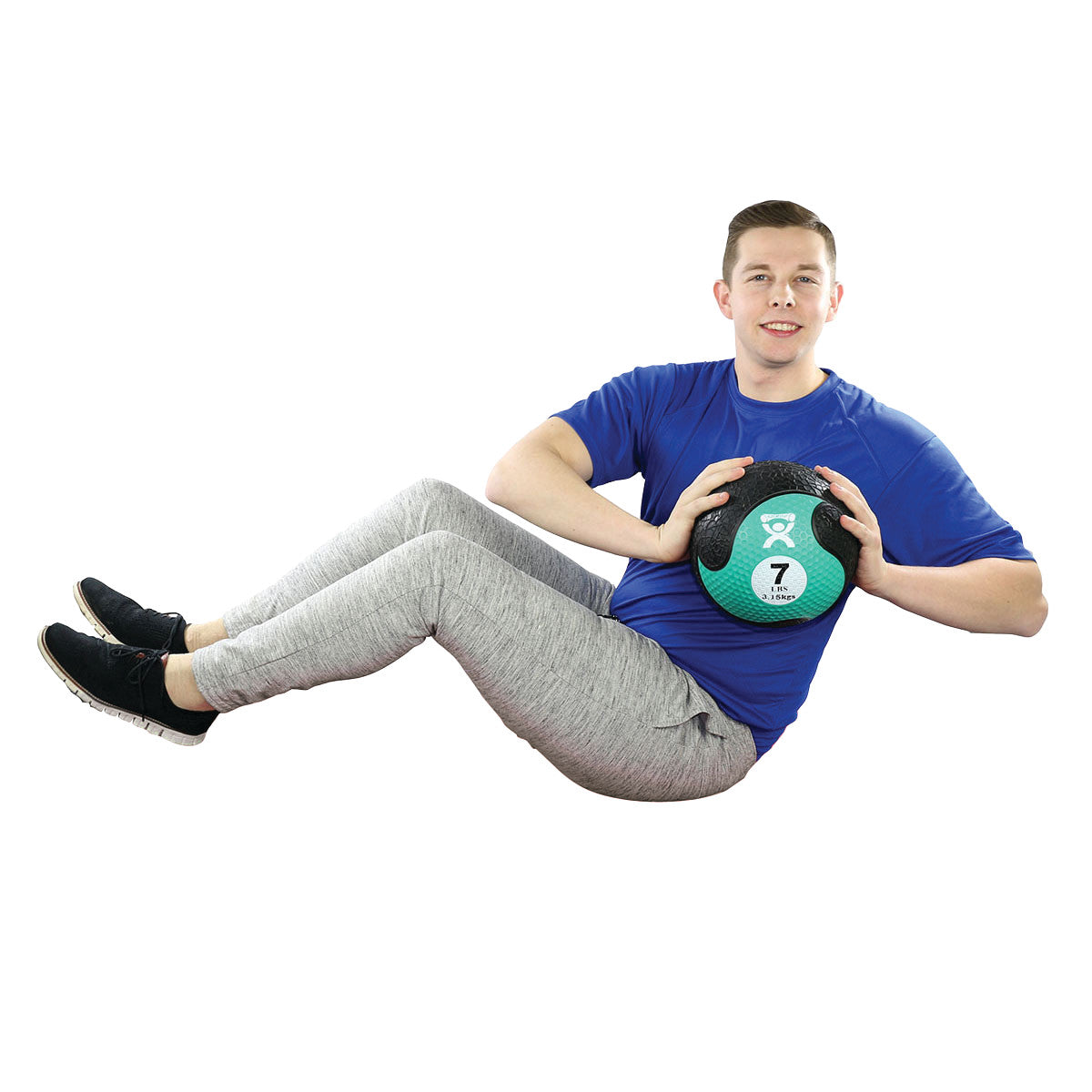 A person holds a CanDo Rubber Medicine Ball while performing an exercise. The ball is labeled "7 lb" and "3.18 kg."