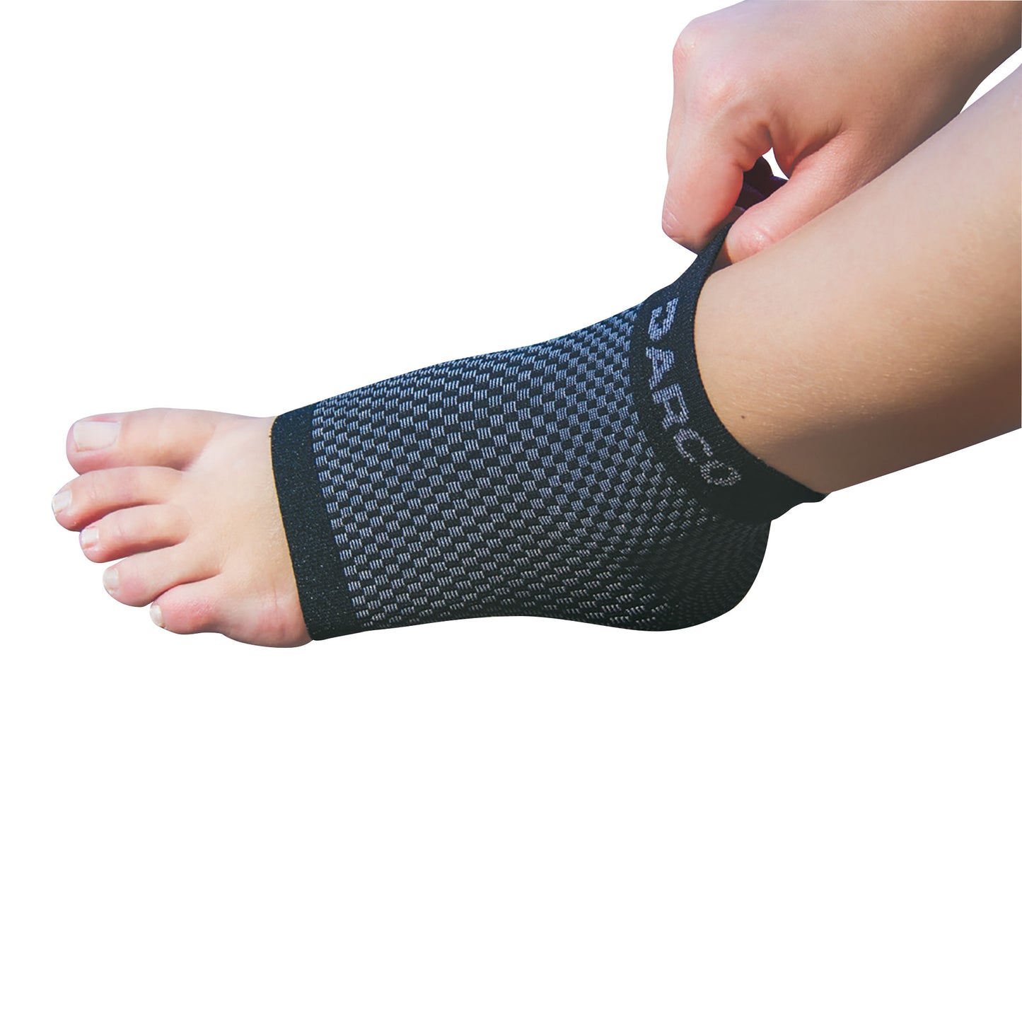 A foot is pictured wearing the DARCO DCS Plantar Fasciitis Sleeve, a black and gray compression sleeve being adjusted by hand.