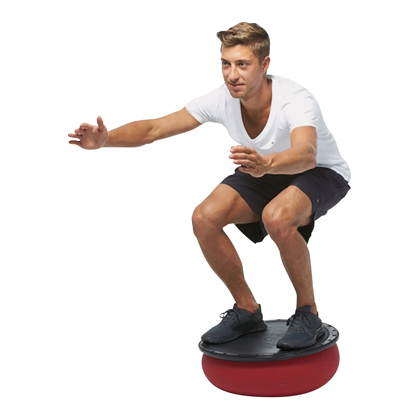 A man balances on a TOGU Jumper Stability Dome, squatting with arms extended, wearing a white shirt and black shorts.