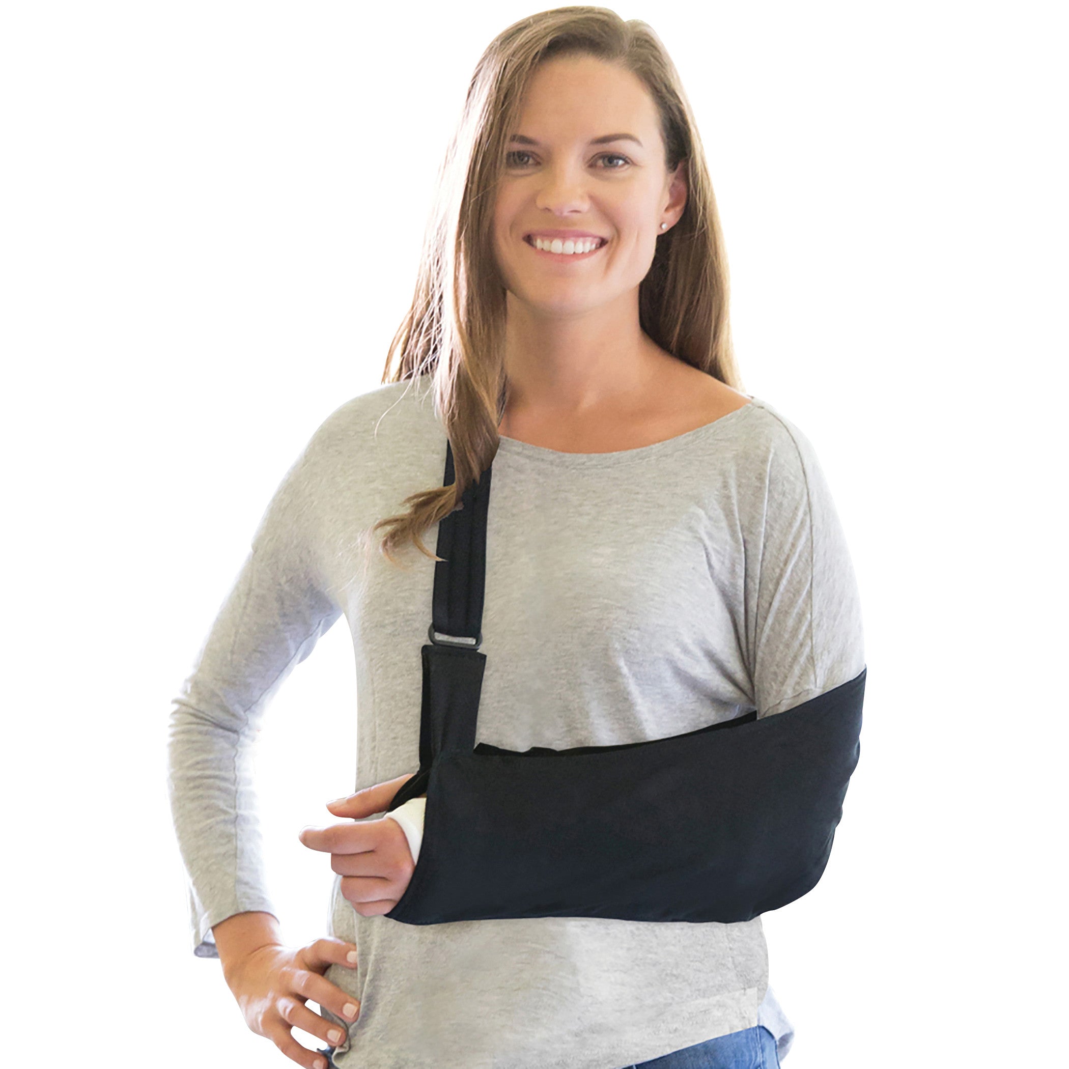 A woman with long hair wears a Brownmed Joslin Ultimate Arm Sling, smiling while holding her injured arm in a black sling.