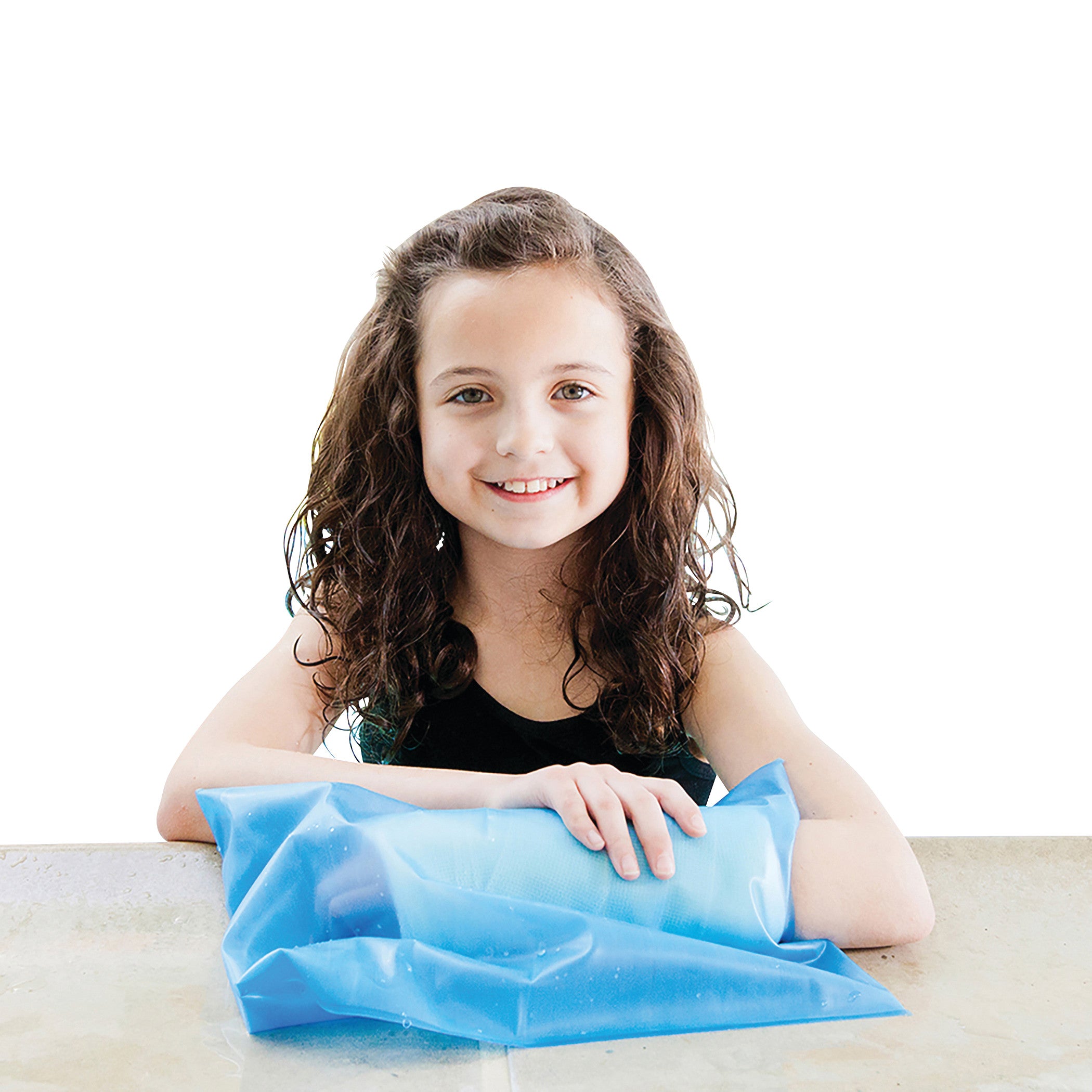A child sits at a table, smiling, with a Brownmed SEAL-TIGHT Sport Cast Protector on their arm, against a plain white background.