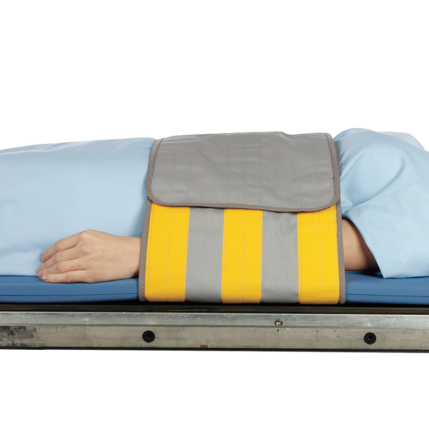 A patient lying on a stretcher with the AliMed Radiolucent Abdominal Immobilizer with One Closure around their midsection.