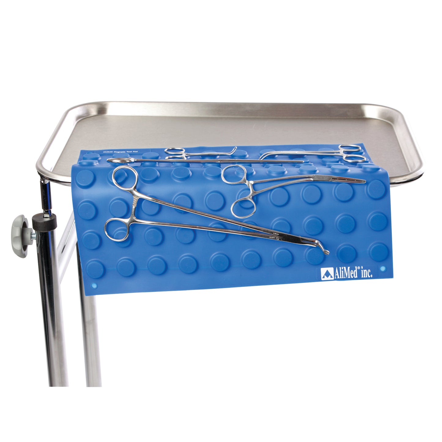 A blue AliMed Magnetic Instrument Pad on a tray, holding several metal surgical tools with a dimpled surface.