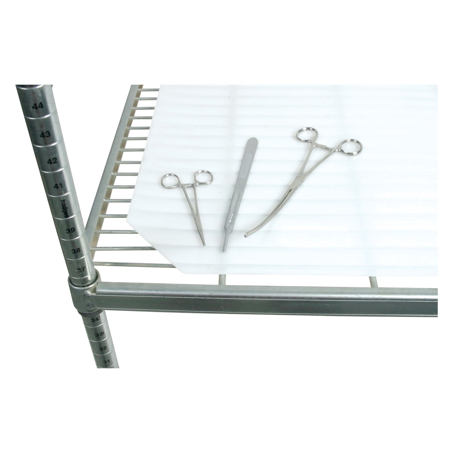 AliMed Antimicrobial Shelf Liner on a metal shelf with surgical instruments, including scissors and a scalpel.