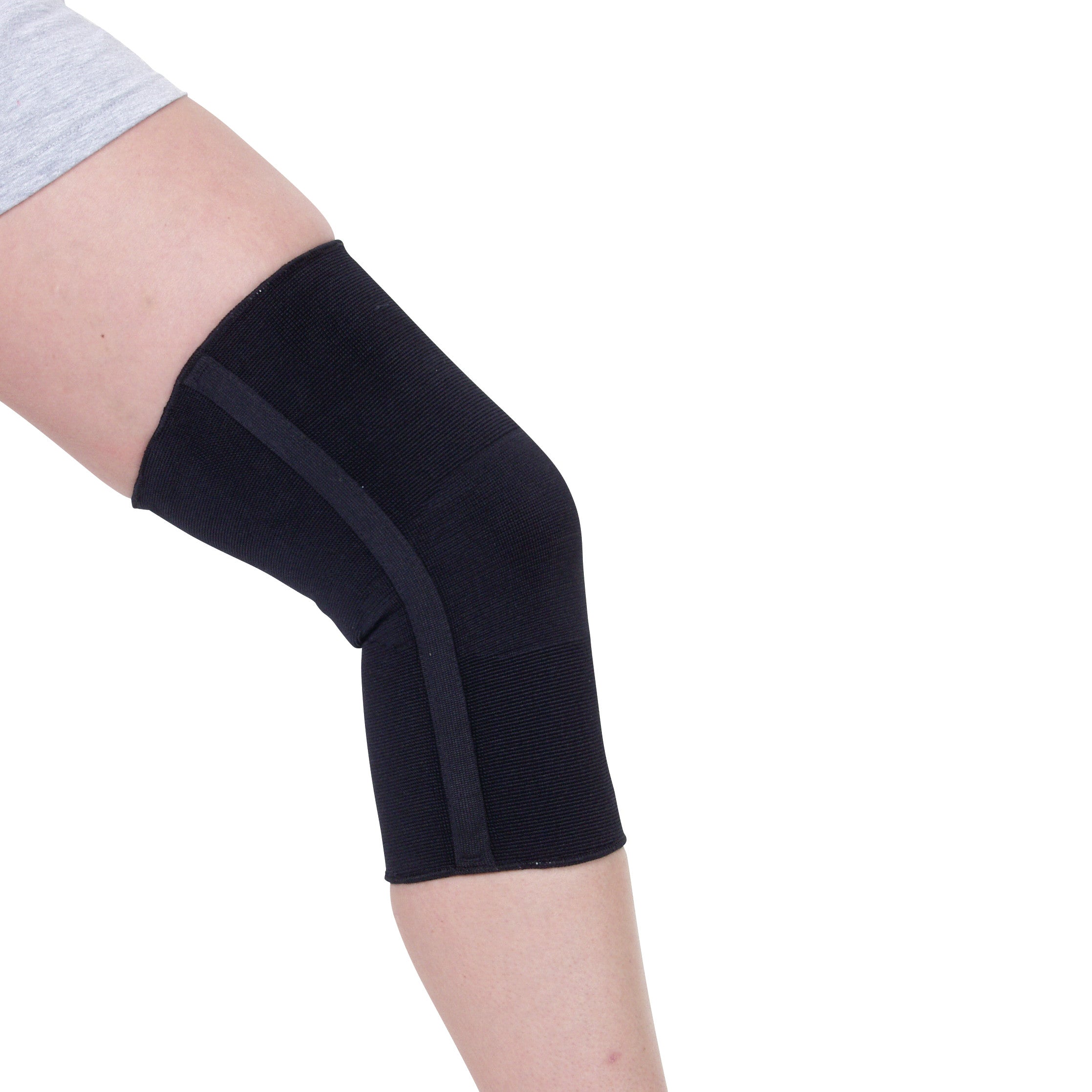 A person wearing an AliMed Knee Brace, which is a black compression sleeve, covering the knee and part of the lower and upper leg.