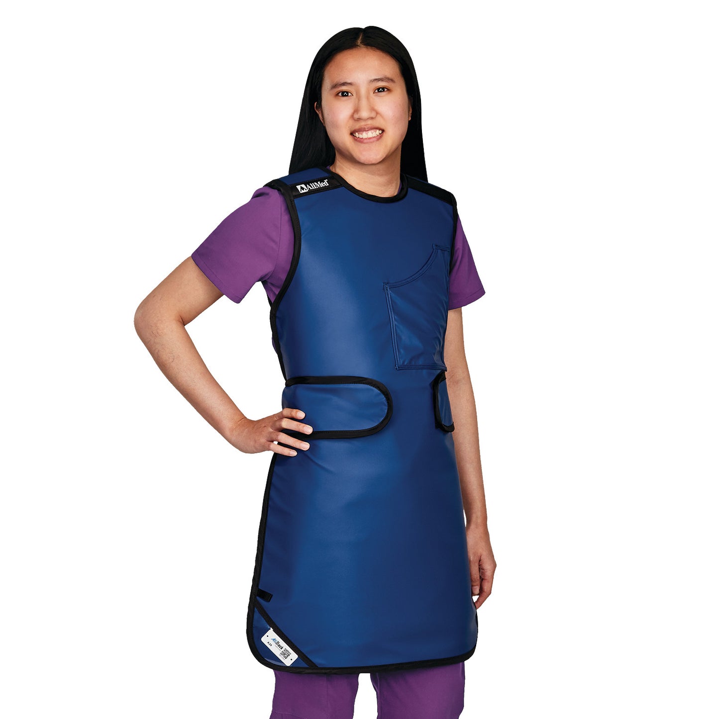 A woman wears the AliMed Grab n Go Flex Weight Reliever Apron, Female, in blue over purple scrubs.