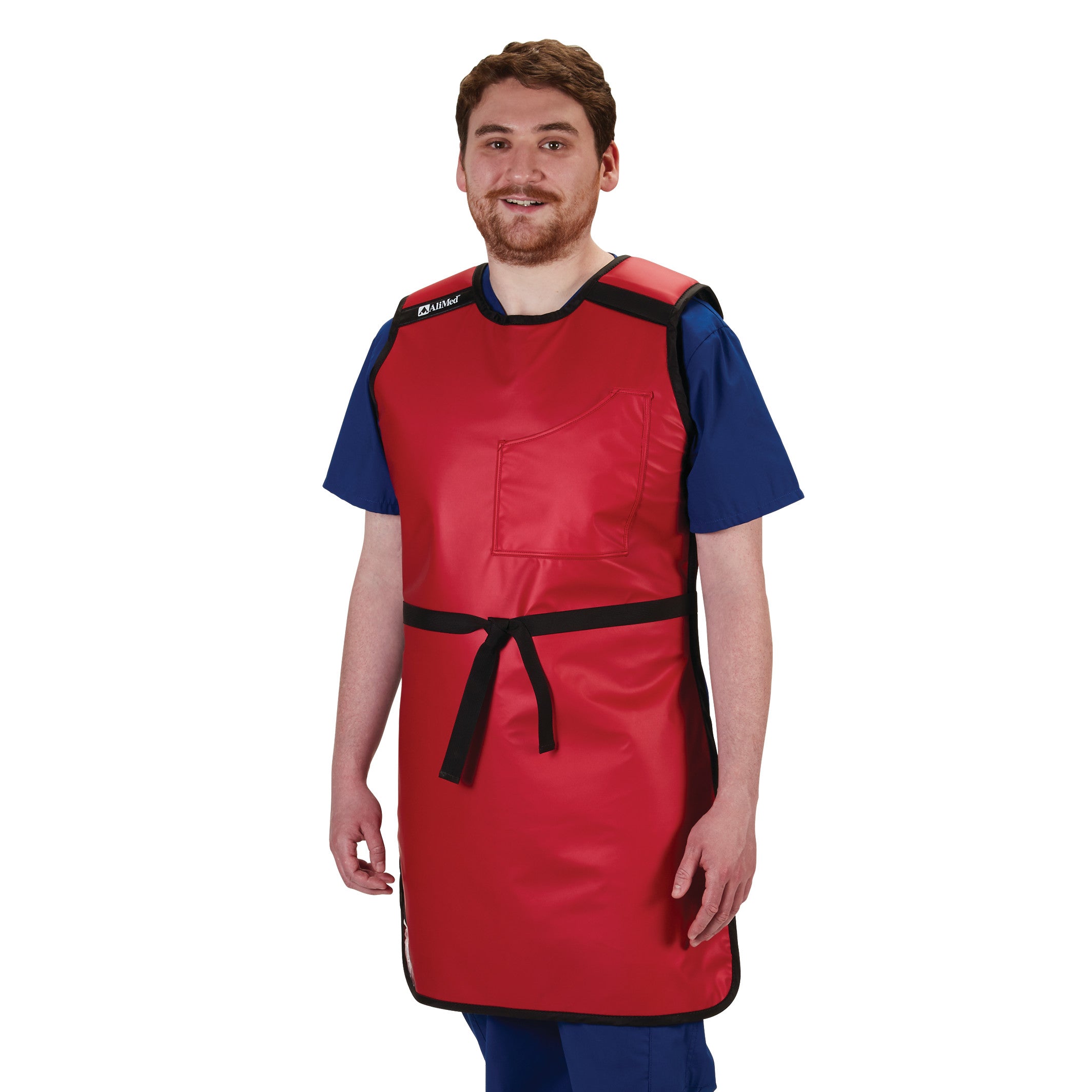 A man wears an AliMed Grab n Go Tie Apron, Male. It's a red protective apron with a black tie, worn over blue scrubs.