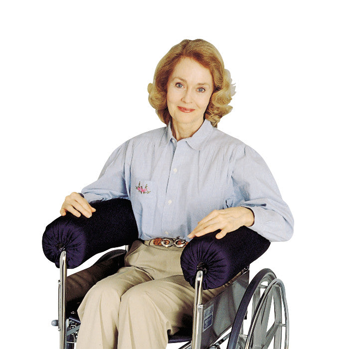 A person in a wheelchair uses the SkiL-Care Lateral Stabilizer Full-Arm Armrest Bolster for support while smiling at the camera.