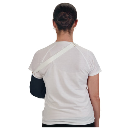 A person facing away, wearing the AliMed Deluxe Envelope Style Arm Sling with a white strap, supporting their right arm.