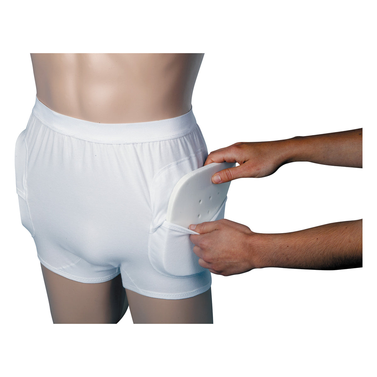 A person inserts an AliMed HipShield X-tra Hip Protector pad into the side pocket of white protective underwear.