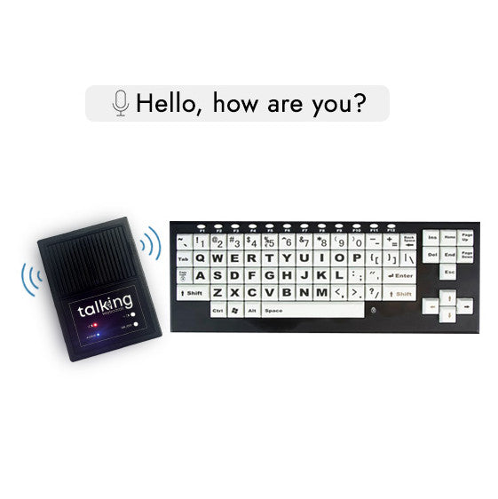 A black Talking Keyboard with large white letters and a separate TextSpeak speak unit, with a hand pointing toward the unit.