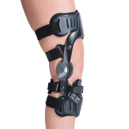 Person wearing an �ssur CTi OTS Knee Brace, featuring black adjustable straps and a sturdy hinge for support and stability.