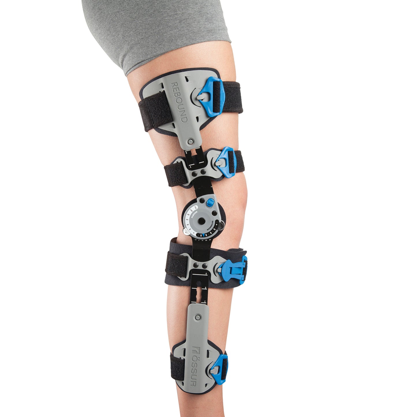 The Ossur Rebound Post-Op Knee Brace with Cool Liner is fitted on a leg, featuring gray and blue straps with adjustable hinges.