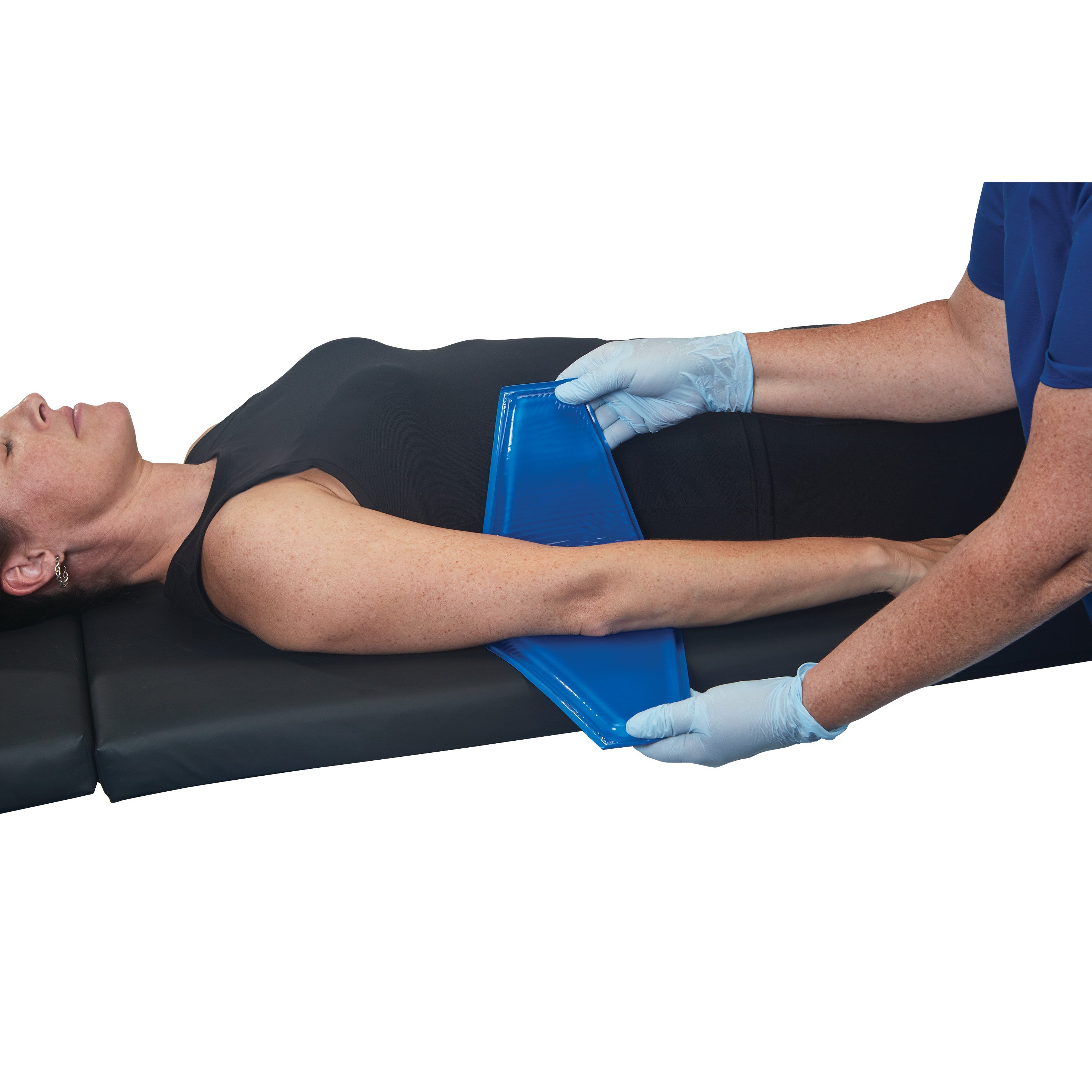 A person lies on a table while a gloved hand applies the AliMed AliBlue Gel Ulnar Nerve Protector to their arm.