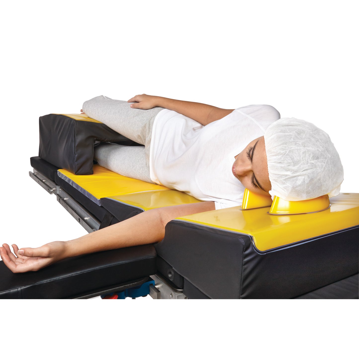 A person lies on their side on an operating table using the AliMed AliLite Lateral Positioning Set with yellow and black cushions.