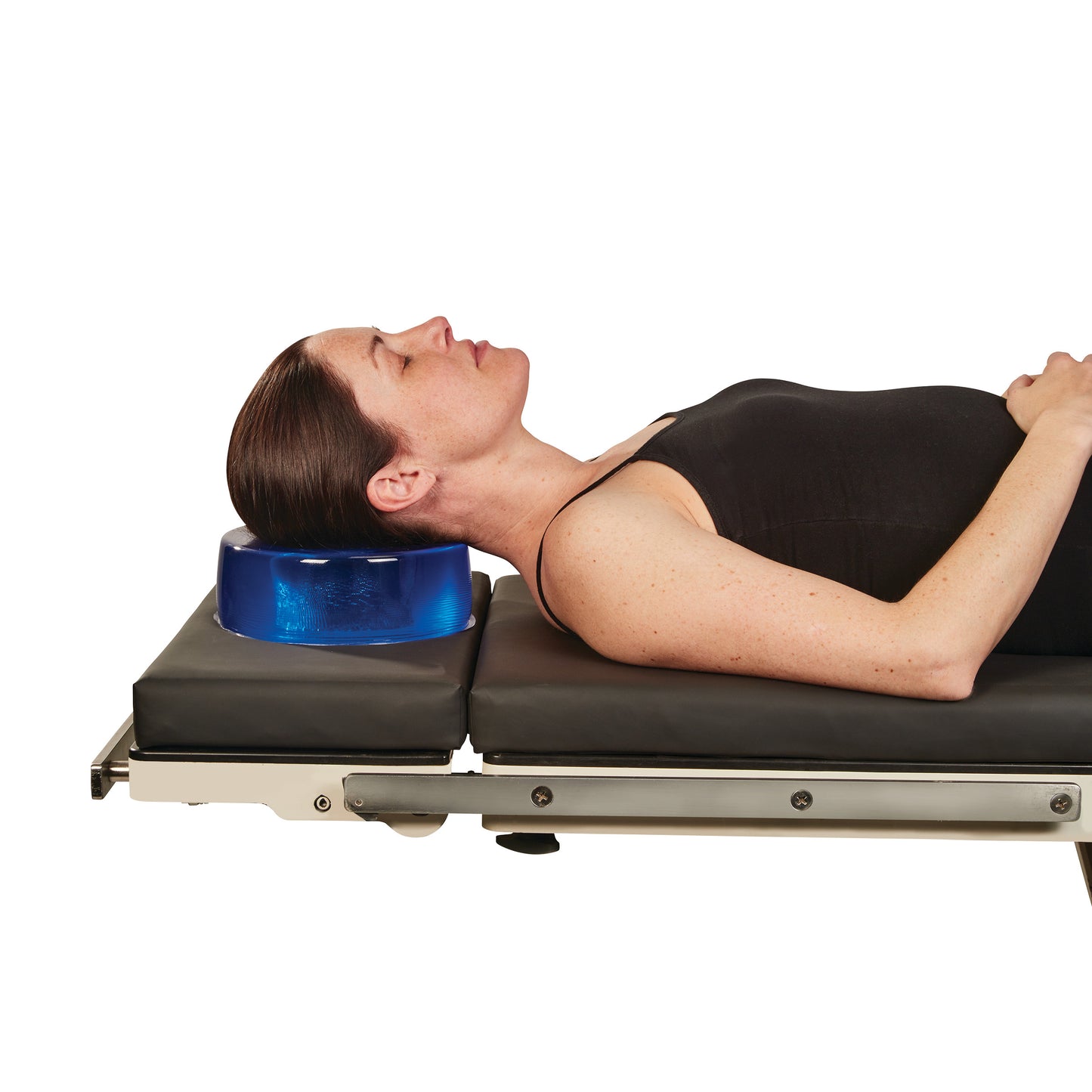 A person lies on a table using the AliMed AliBlue Gel Head Donut to support their head and neck.