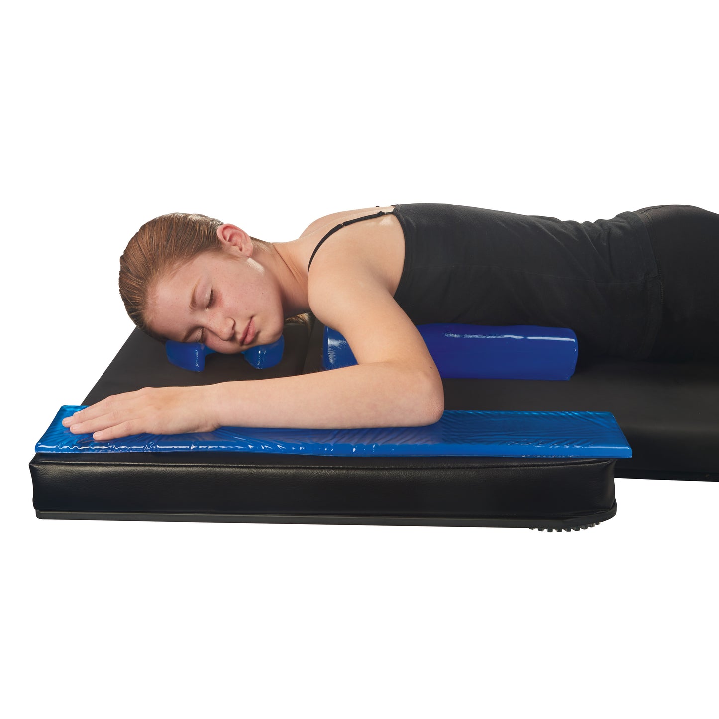 A person lies face down using the AliMed AliBlue Gel Chest Roll for support on a black mat, with eyes closed and arms extended.